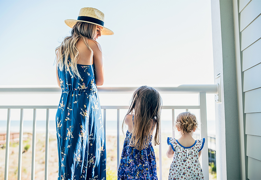 a woman and two children standing on a balcony