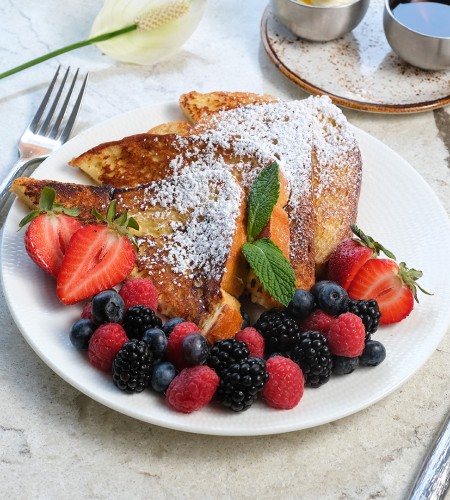 a plate of french toast with fruit