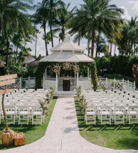 a wedding venue with white chairs and a gazebo