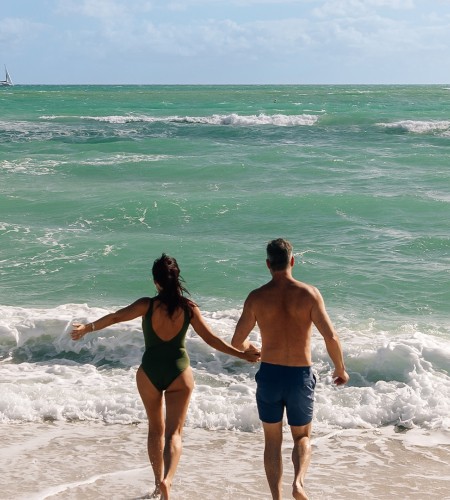 a man and woman walking on a beach