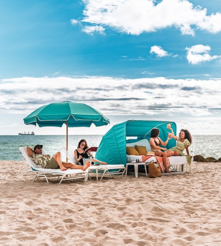 a group of people sitting on a beach with umbrellas