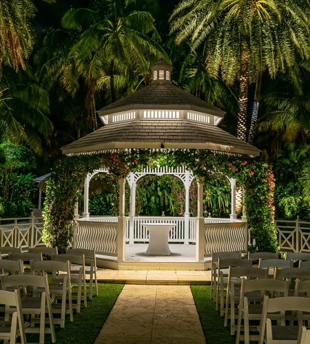 a gazebo with chairs and trees in the background