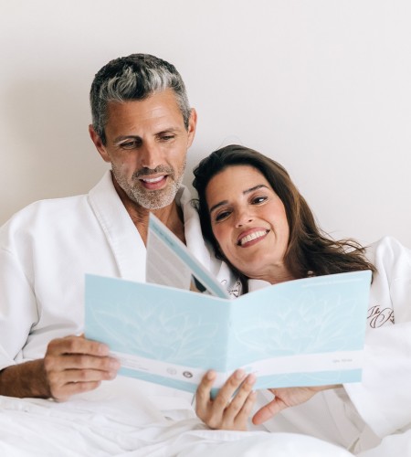 a man and woman in white robes reading a book