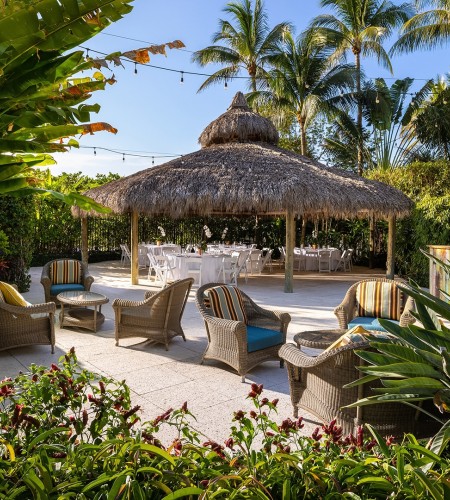 a patio with chairs and a straw roof