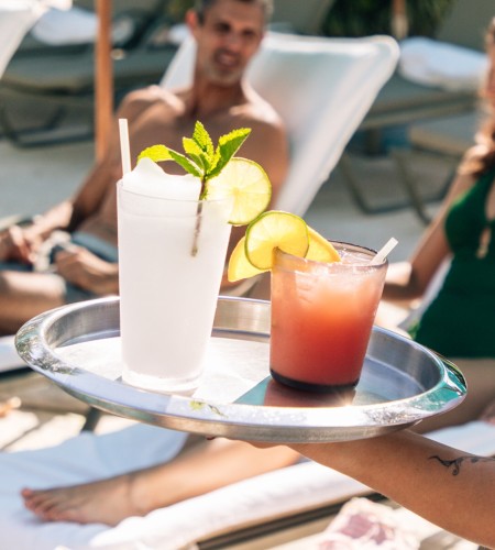 a person holding a tray with drinks on it