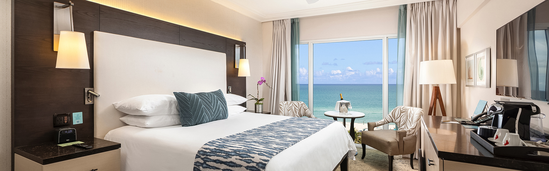 a hotel room with a large window overlooking the ocean