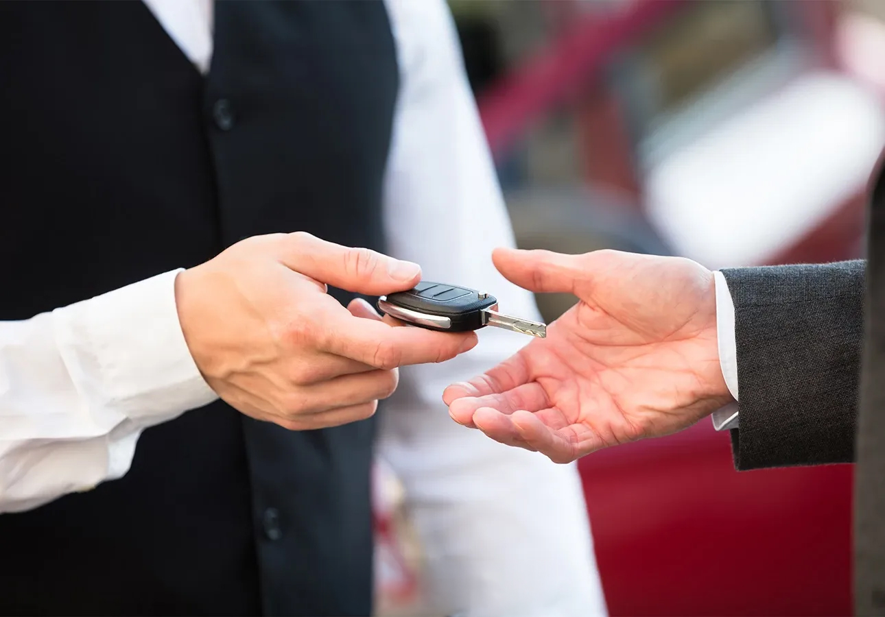a person handing a car key to another person