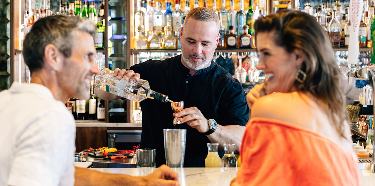 a man pouring a drink into a glass