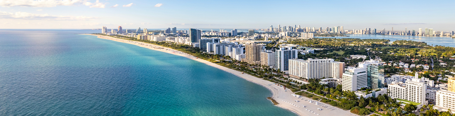 a beach with buildings and a city in the background