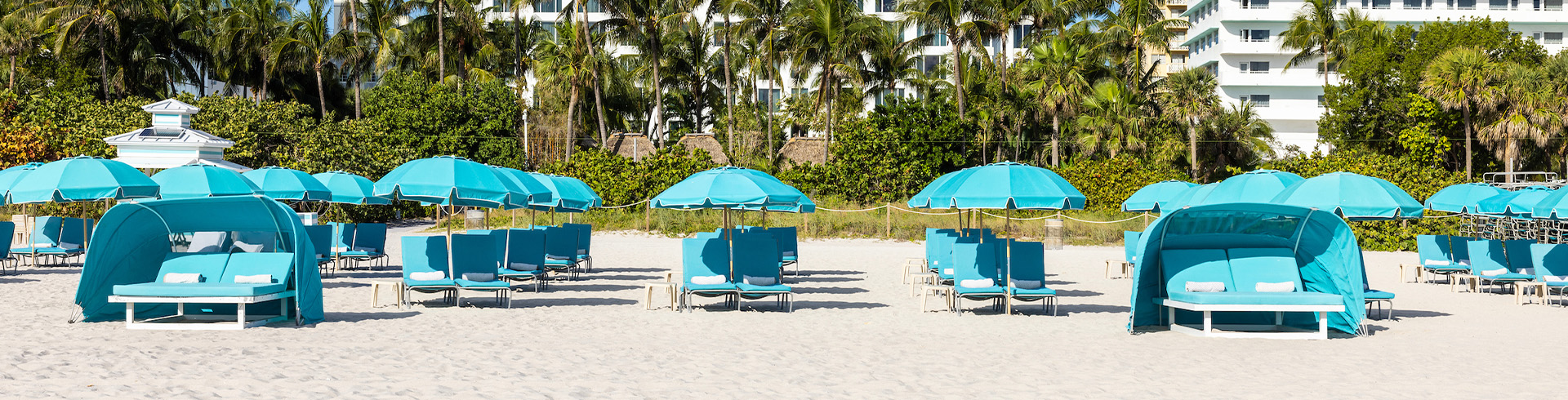 a group of blue chairs and umbrellas on a beach