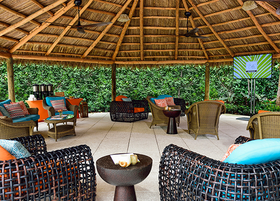 a patio with wicker furniture and a thatched roof