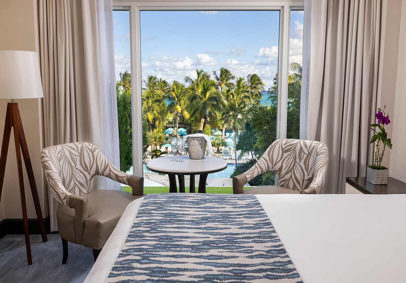 a room with a table and chairs and a view of the ocean