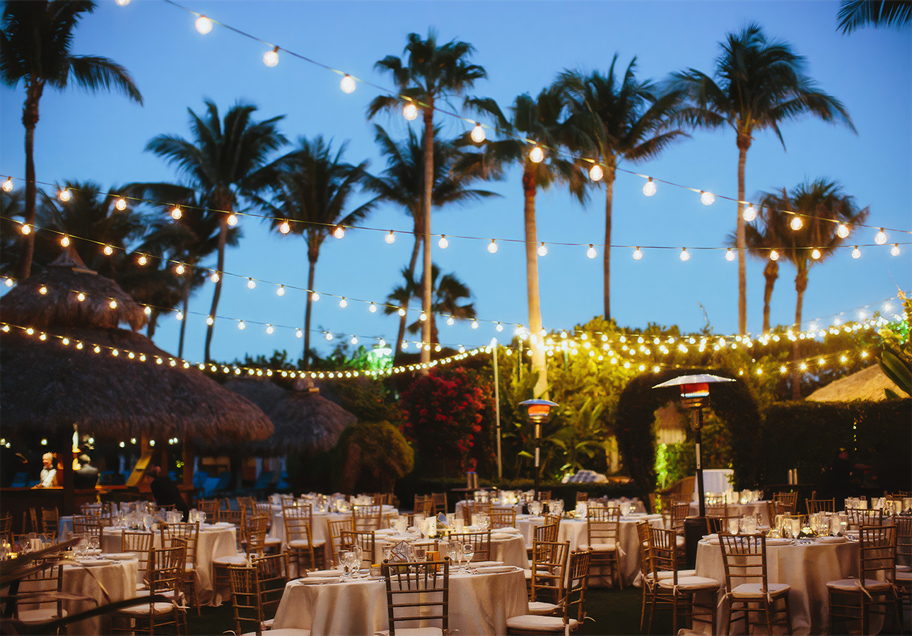 a group of tables and chairs with white cloths and lights