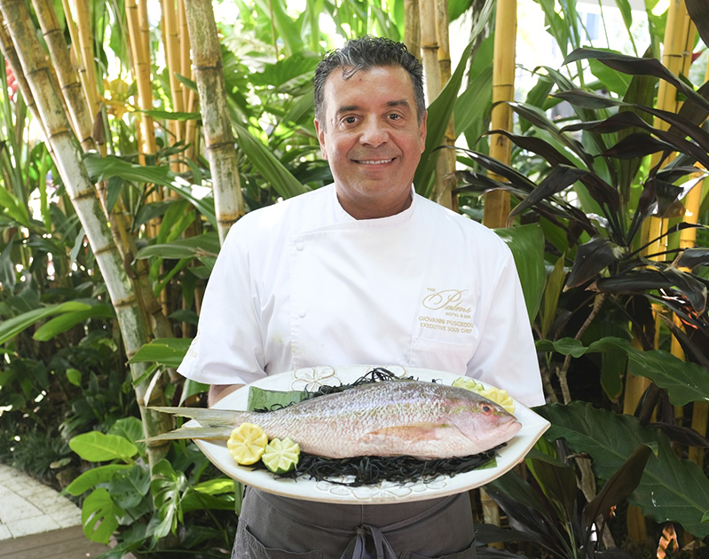 a man holding a plate of fish