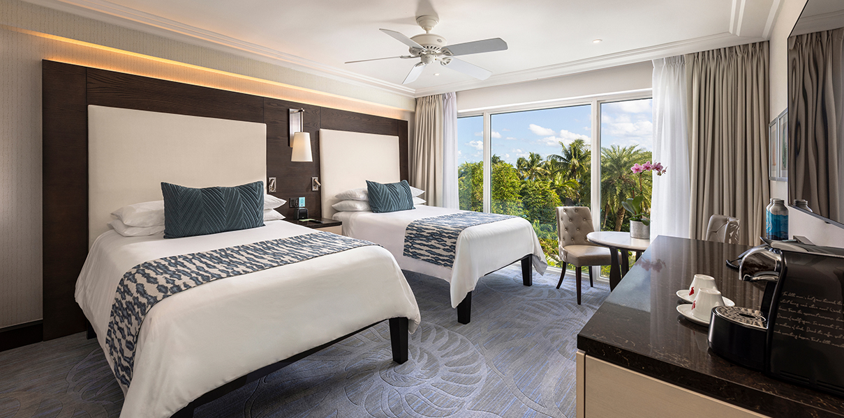 a room with two beds and a table and chairs