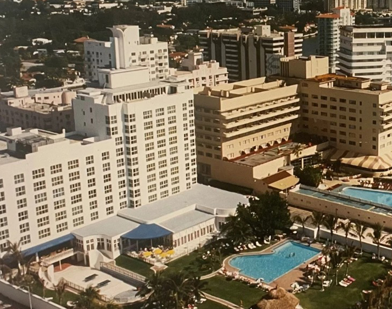 a large white building with a pool in front of it