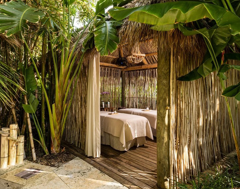 a massage tables under a straw hut