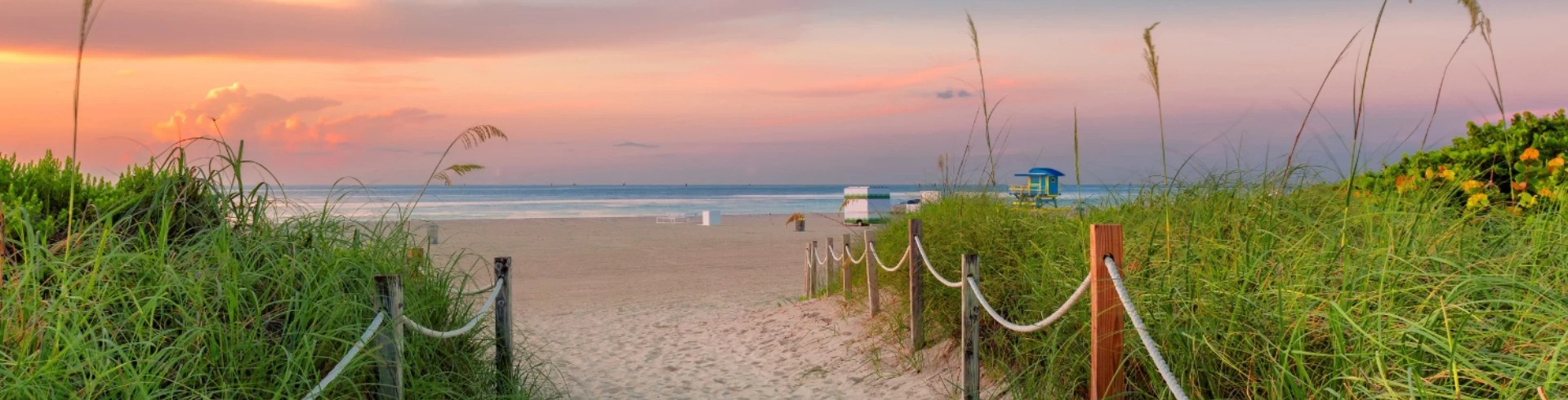a beach with a rope fence and grass