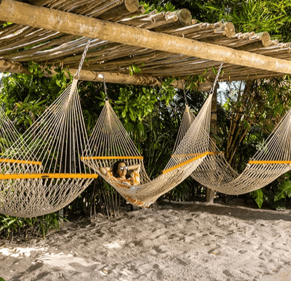 a woman lying in hammocks under a canopy