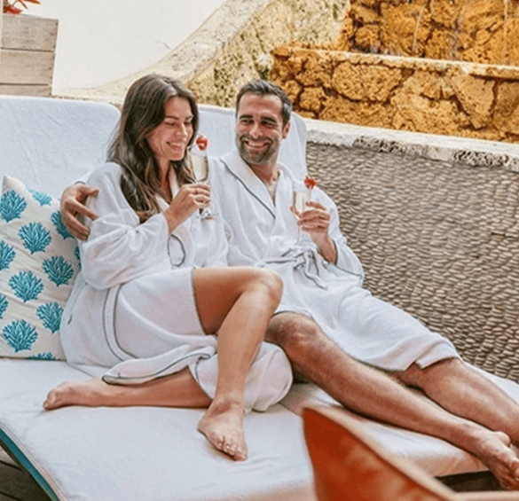 a man and woman in bathrobes sitting on a lounge chair