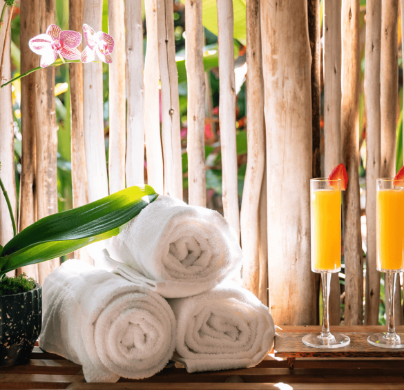 a stack of towels and two glasses of orange juice