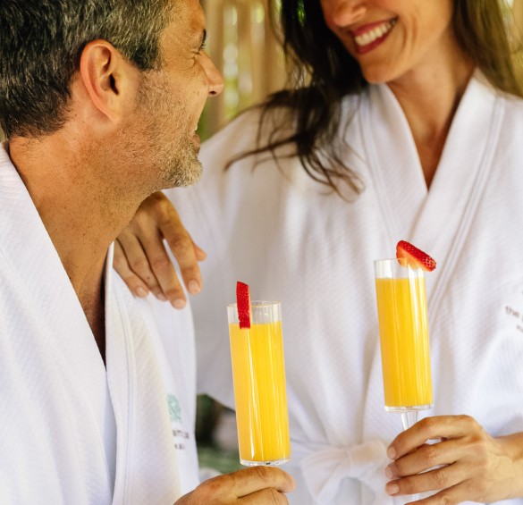 a man and woman in bathrobes holding drinks