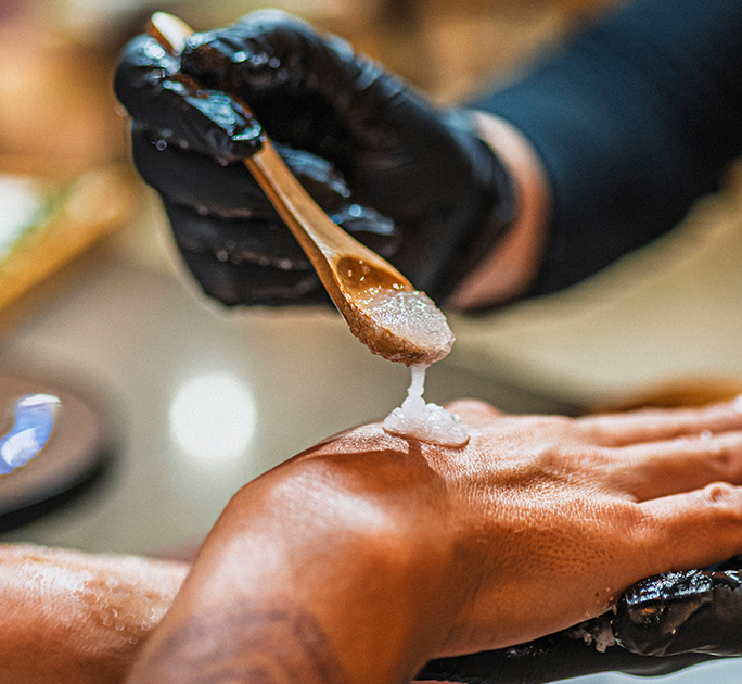 a person's hand with a wooden spoon