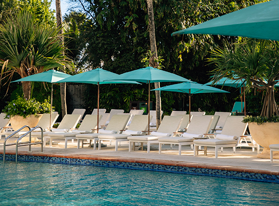 a pool with lounge chairs and umbrellas