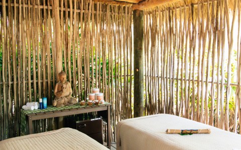 a room with two beds and a bamboo wall