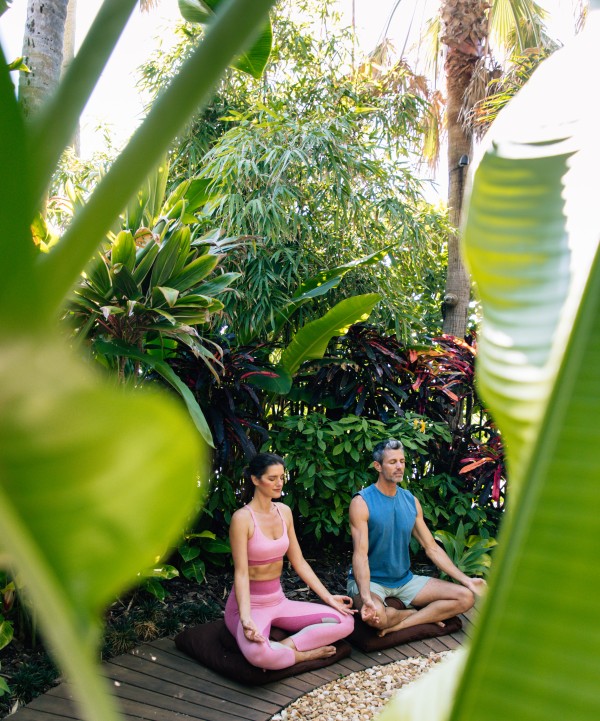 a man and woman meditating outside