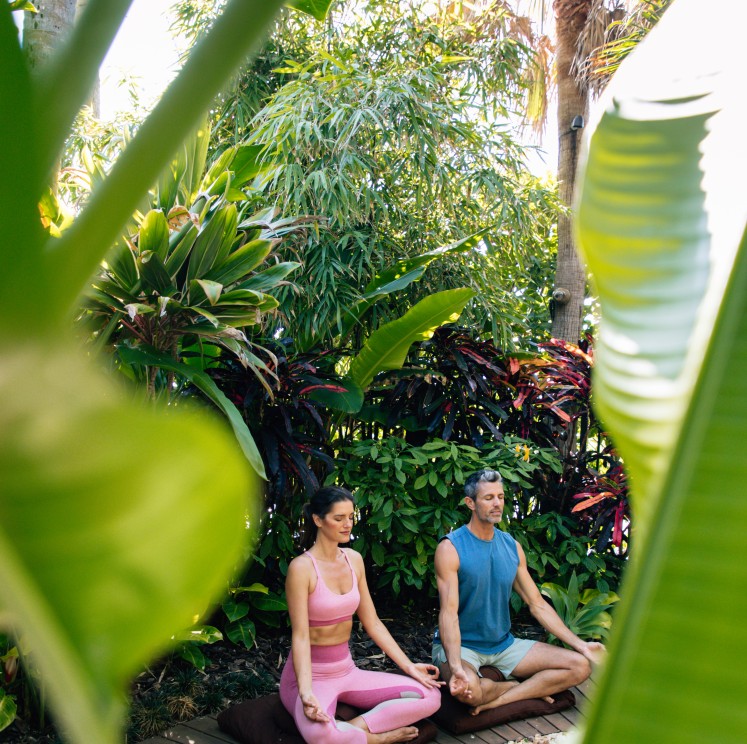 a man and woman meditating outside