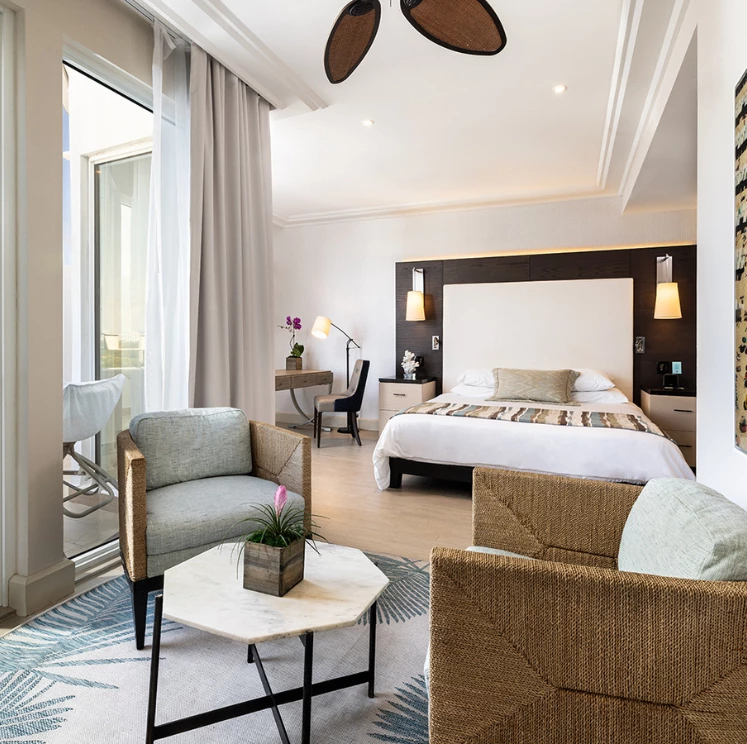 A wide view of a hotel room with a sitting area and a bed
