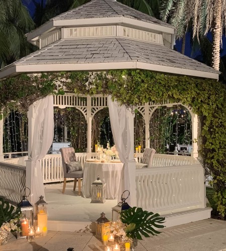 a gazebo with a table and chairs and candles