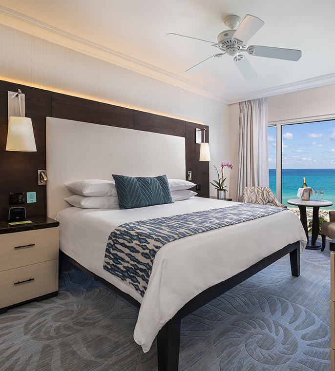 a room with a bed and a window with a view of the ocean