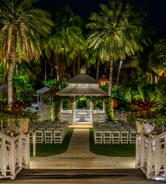 a wedding venue with palm trees and a gazebo