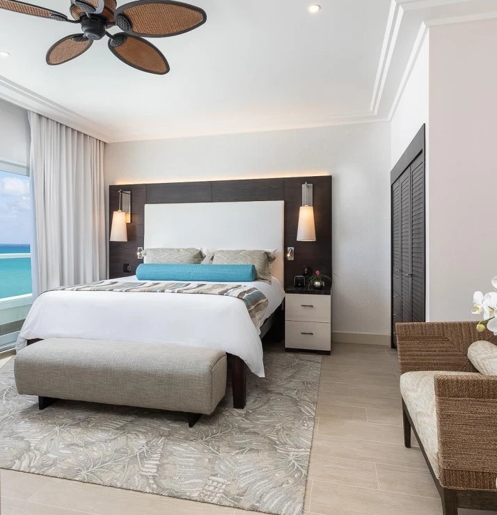 a guest room with white decor and an ocean view