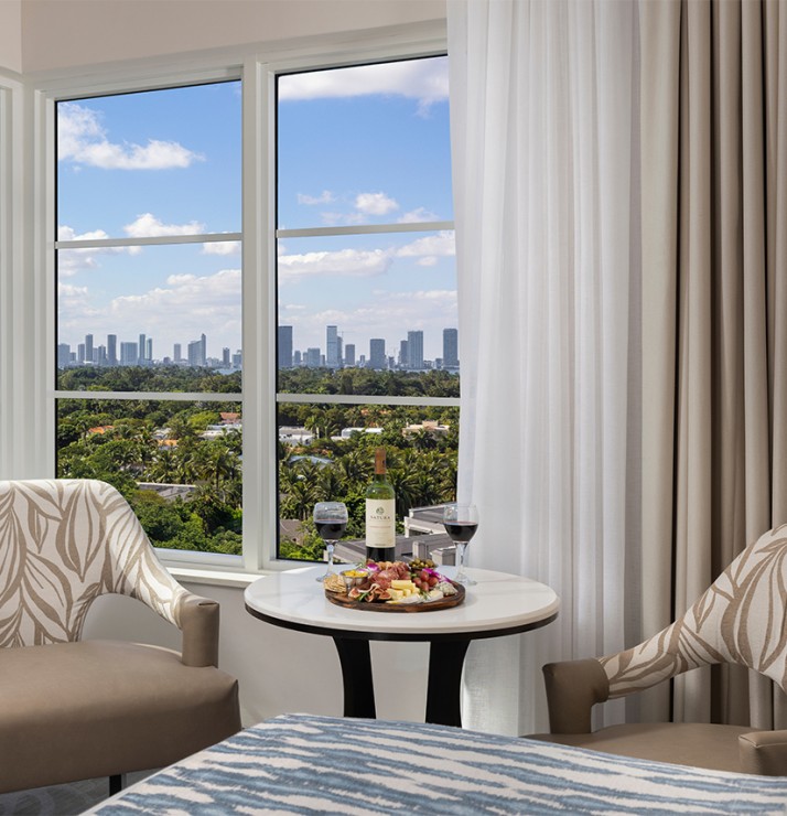 a table with food and wine in front of a window