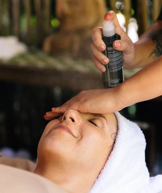 a person spraying a woman's face