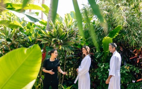 a group of people in white robes standing in a garden