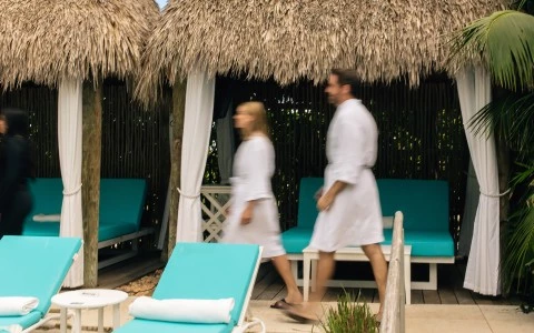 a man and woman walking near chairs