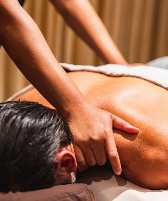 a person massaging a man's back