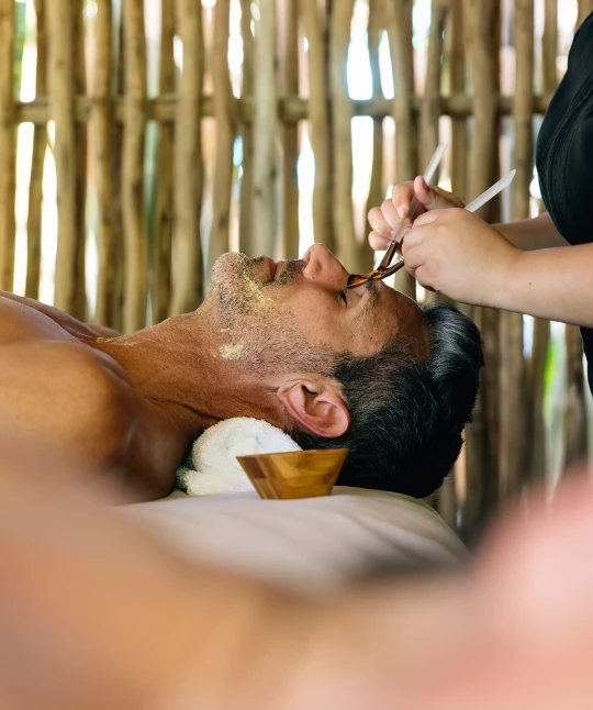 a man lying down with a brush on his face