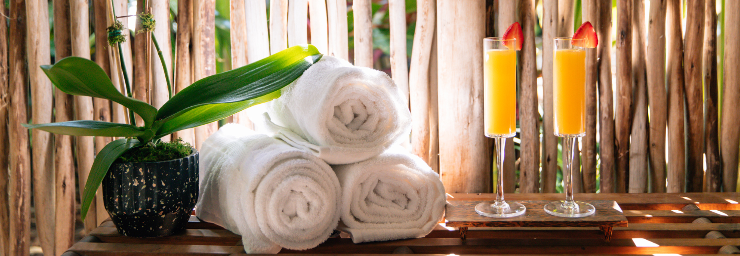 a stack of towels and a glass of orange juice