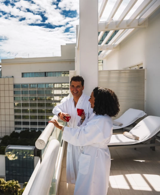 a man and woman in white robes on a balcony