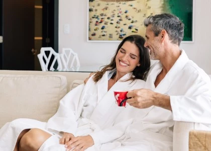 a man and woman in white robes sitting on a couch