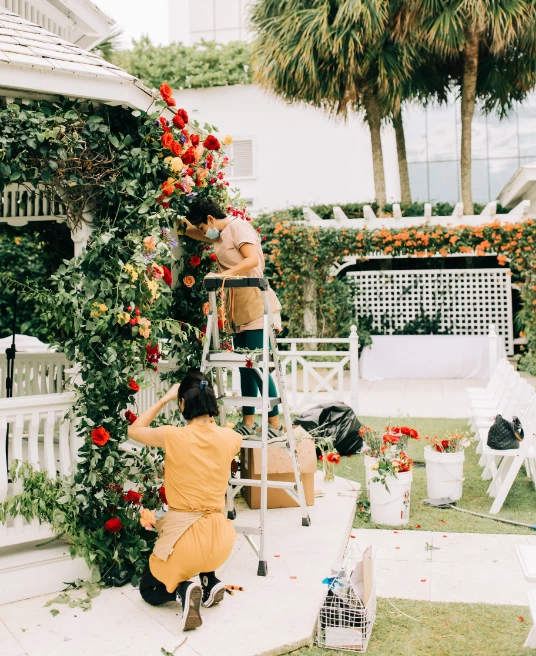 a group of people working on a flower arch