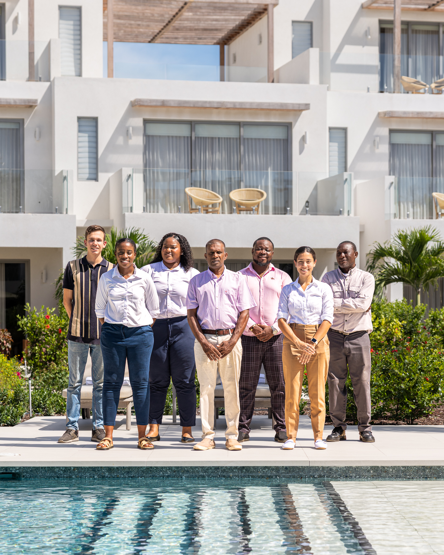 a group of people standing in front of a pool