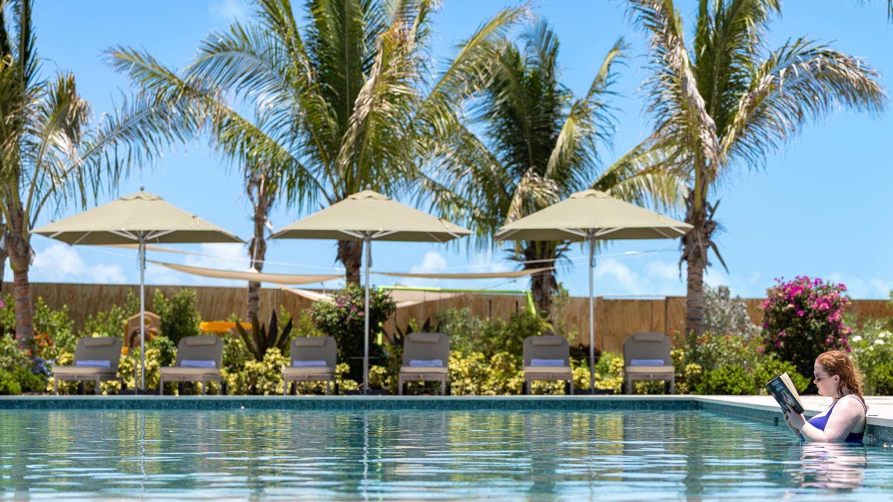 a pool with chairs and umbrellas