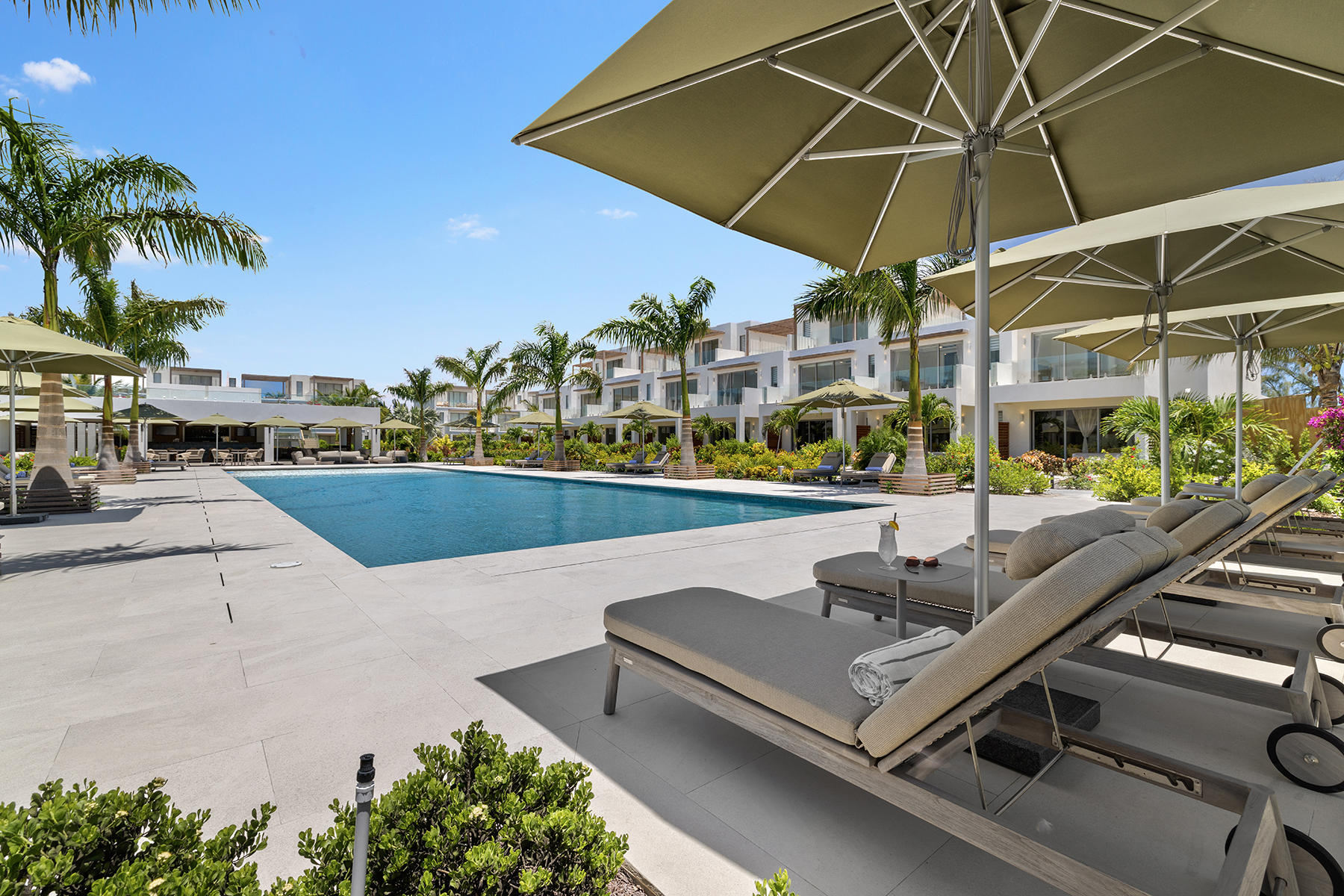 a pool with lounge chairs and umbrellas
