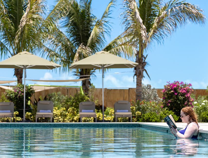 a woman reading a book in a pool